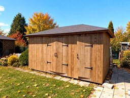 A wooden shed with double doors sits in a garden surrounded by colorful autumn foliage.